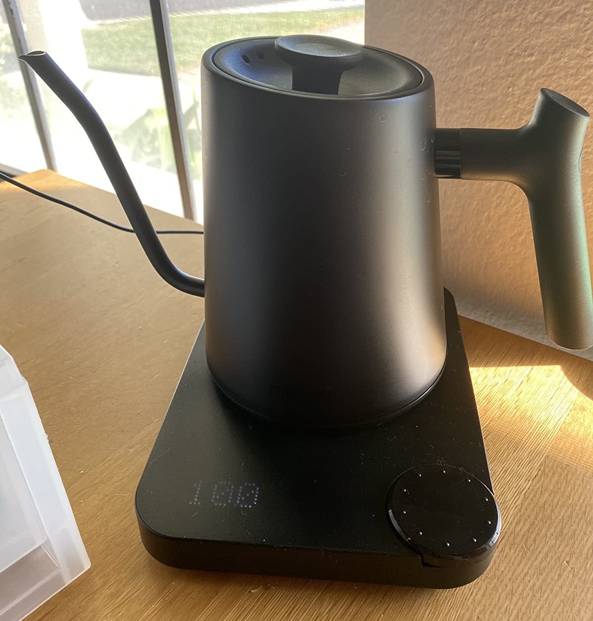 A matte black kettle sitting on the electric warming base 