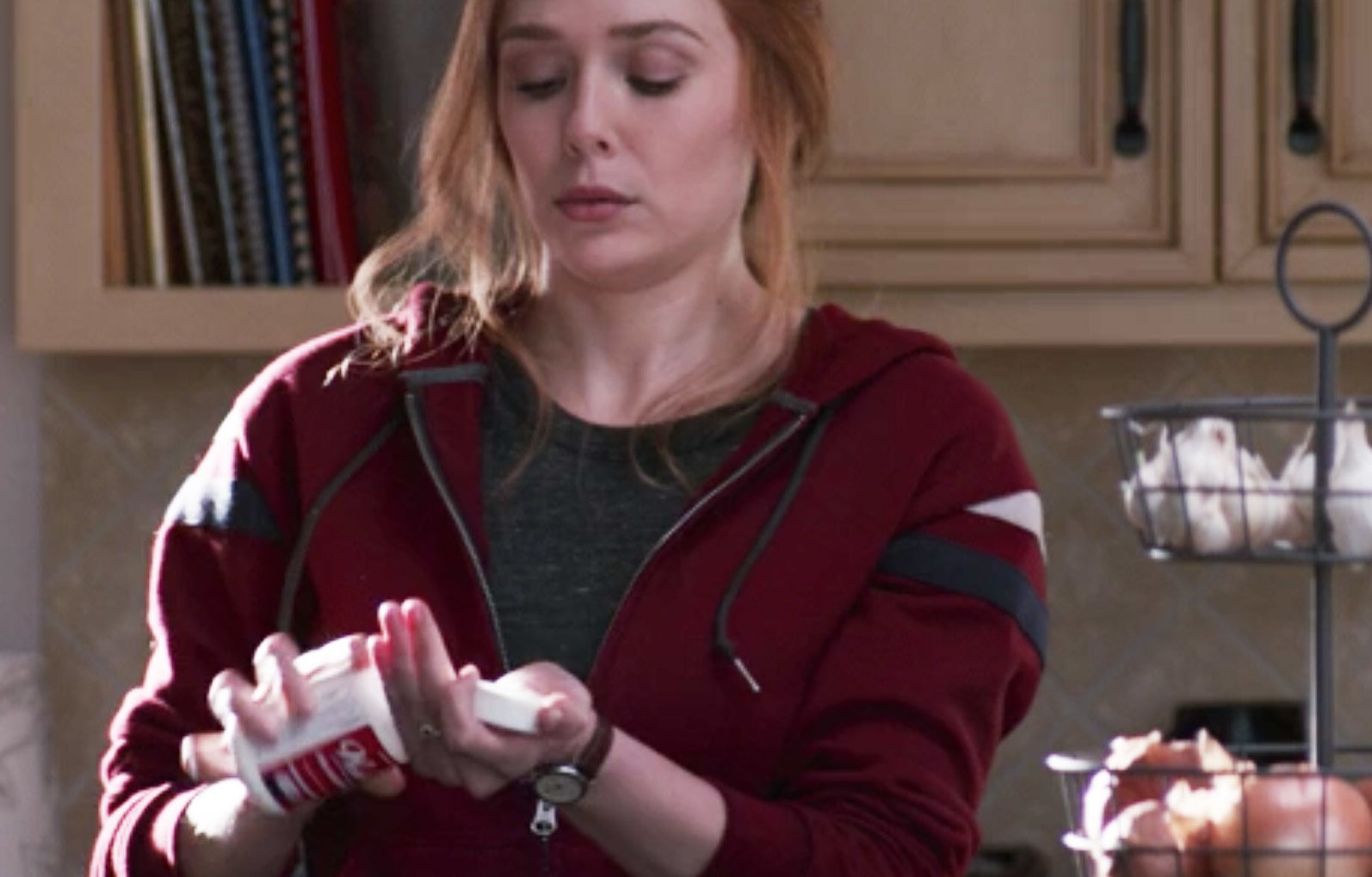 Wanda pouring a pill from a bottle into her hand