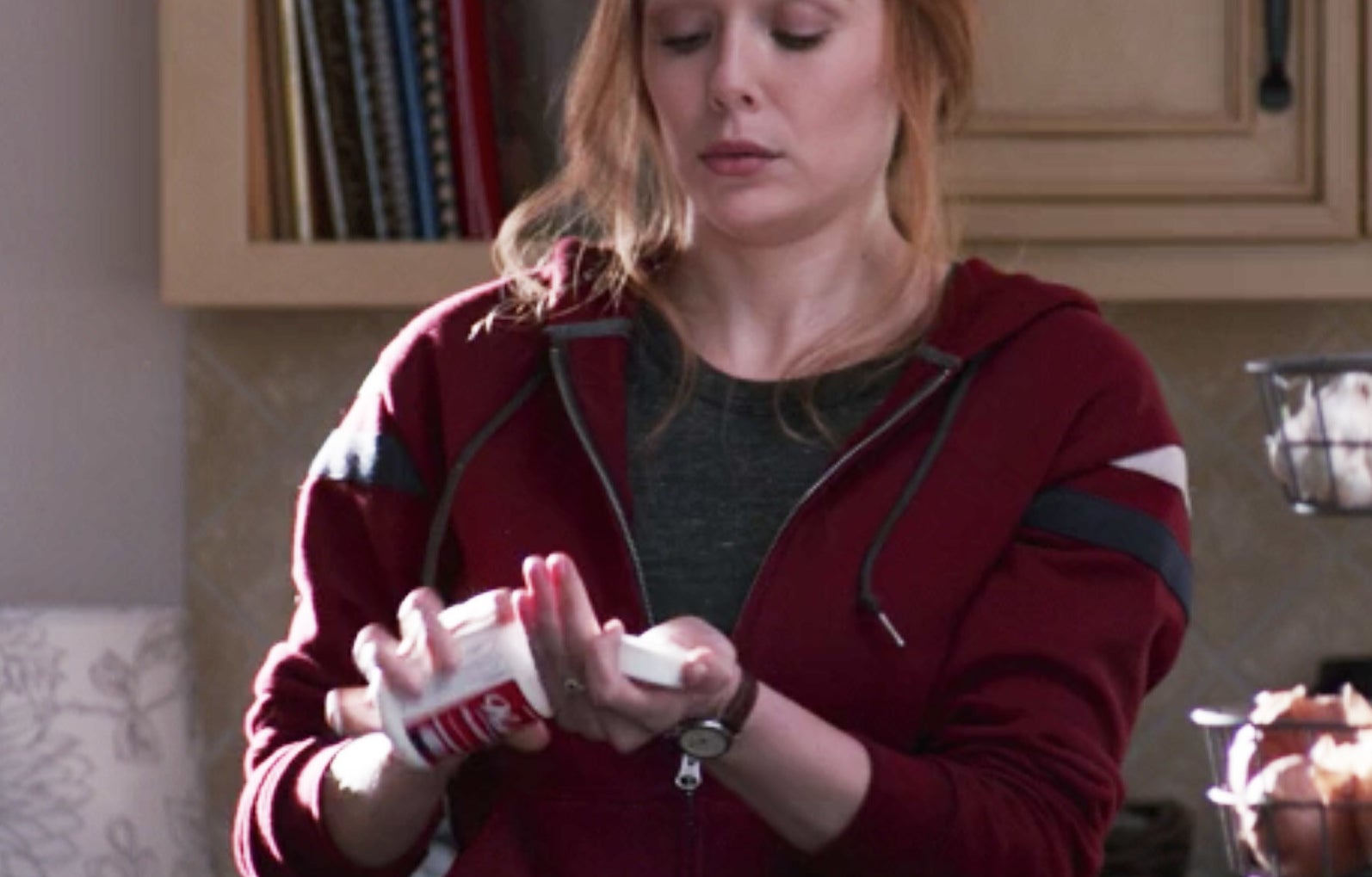 Wanda pouring a pill from a bottle into her hand