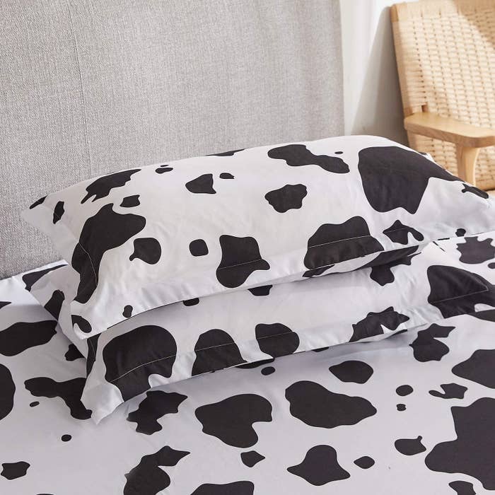 The cow print bed sheets on a bed
