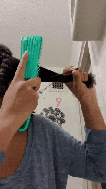 Reviewer detangling hair with brush