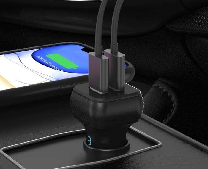 the usb charger plugged inside in someone&#x27;s car with two usb cords plugged into it