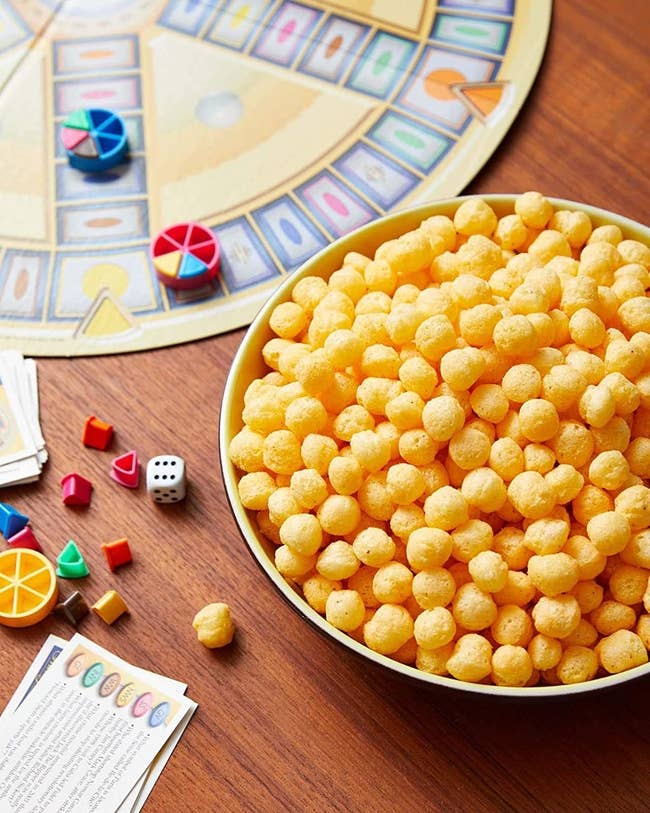bowl of the cheeseballs beside a board game