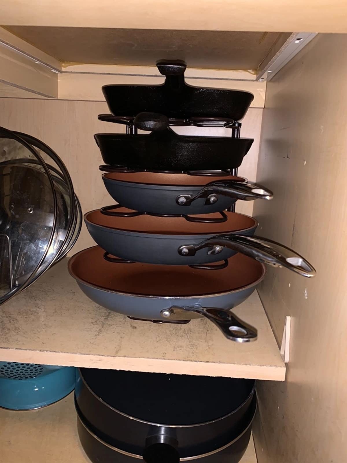 reviewer&#x27;s cabinet with the vertical rack on a shelf holding five different size pans