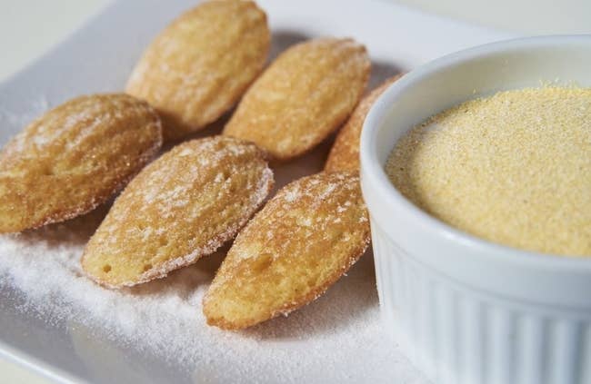 plate of cornbread madeleines beside of a bowl of corn mill