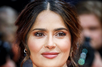 Salma Hayek wears a black dress with red designs on it for the premiere of The Roads Not Taken at the Berlin Film Festival on February 26, 2020