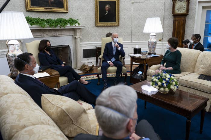 Lawmakers sit socially distant on couches around the Oval Office in masks