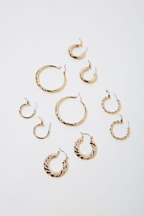 Five sets of gold hoop earrings in various styles