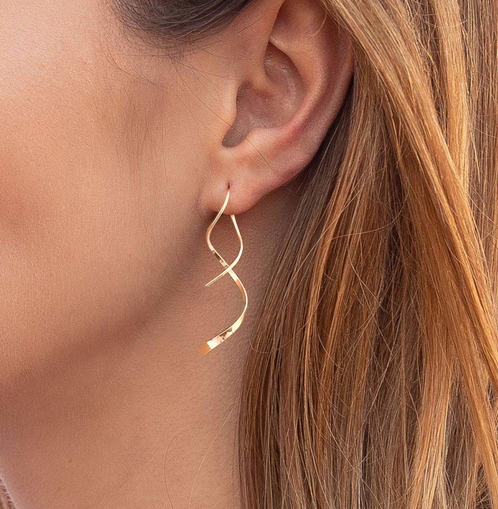 model wearing simple drop earrings in a spiral metal design