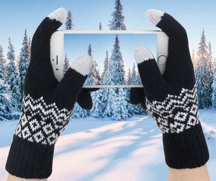 A person taking a picture while wearing the gloves