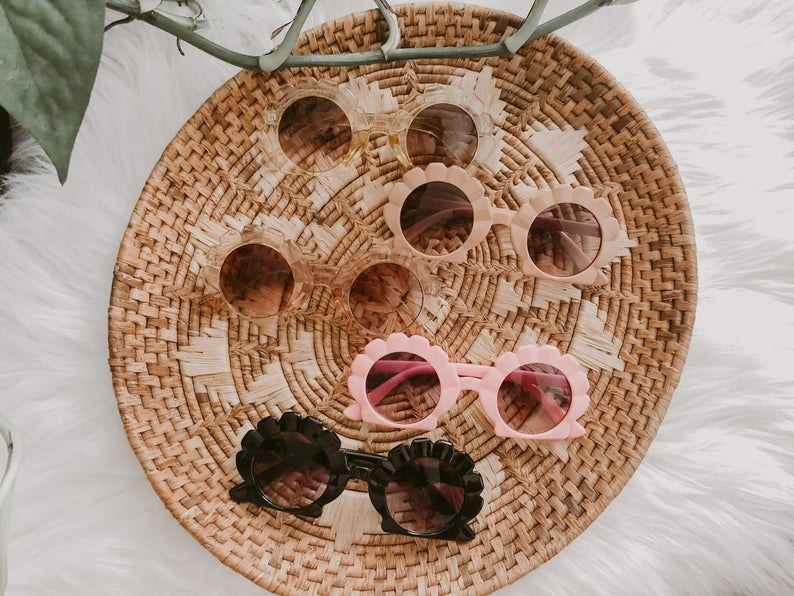 woven basket with five pairs of differntly colors sunglasses with the frame that look like seashells