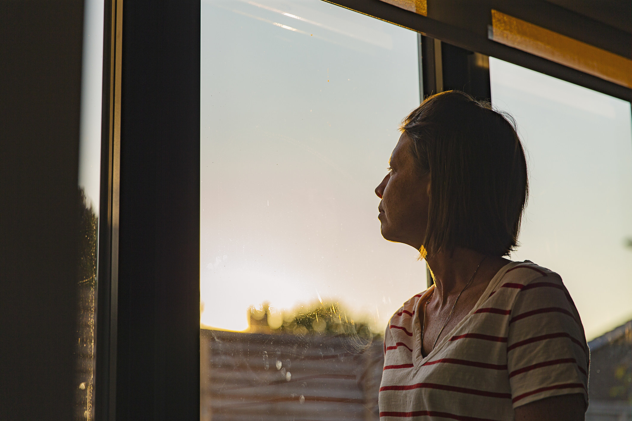 A woman looking out a window pensively