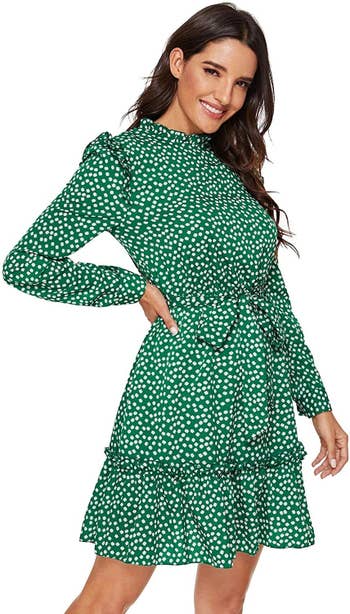 Model wearing the tie-waist long-sleeve dress in green printed with little white daisies