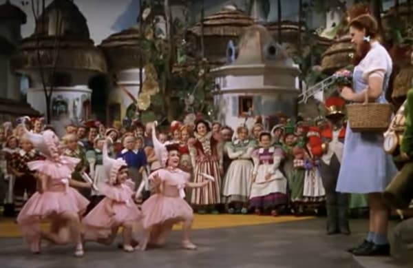 Judy Garland standing in Munchkinland with the ballerinas