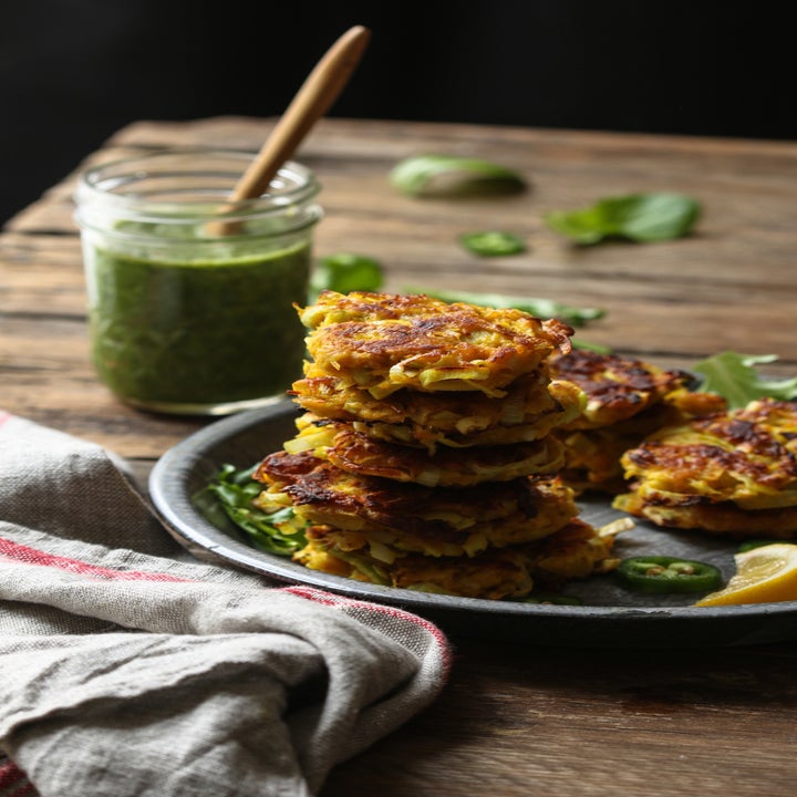 A stack of parsnip and leek pancakes with green sauce on the side.