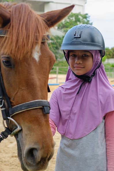 Girl standing with horse