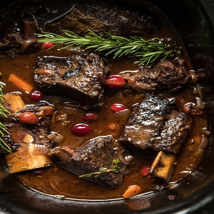 Short ribs cooking in a cranberry beef stock sauce.
