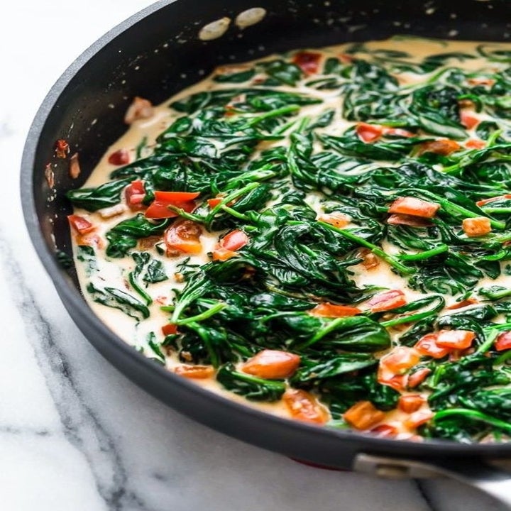 Spinach and tomatoes cooking in a cream sauce.