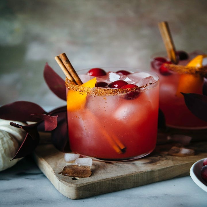 Two cranberry orange margaritas with cinnamon sticks.