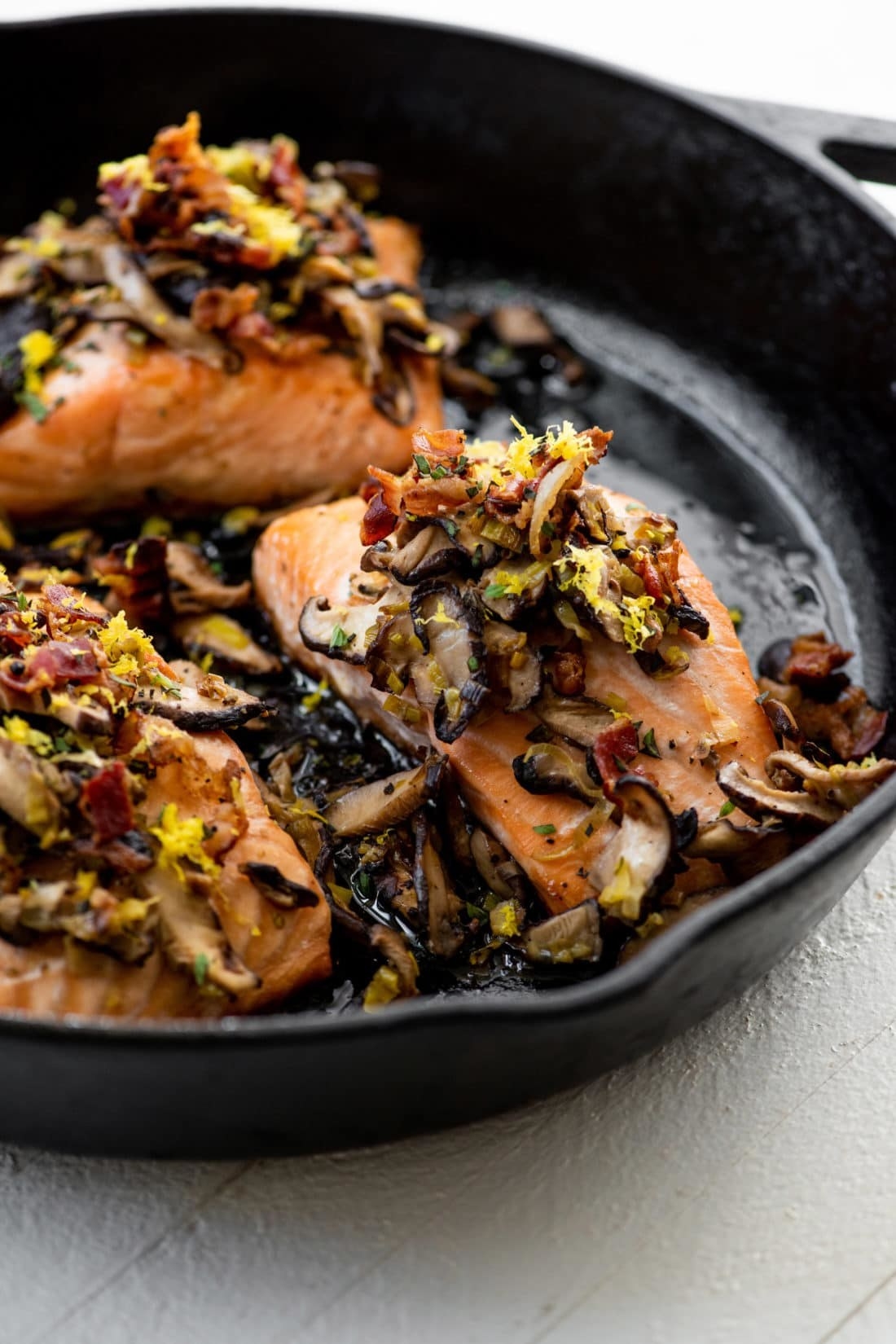 Salmon with leeks and mushrooms in a skillet.