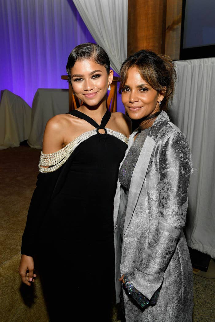  Zendaya&#x27;s wearing an off-the-shoulder dress with strings of pearls as she poses with Halley Berry who&#x27;s wearing a dress and matching coat