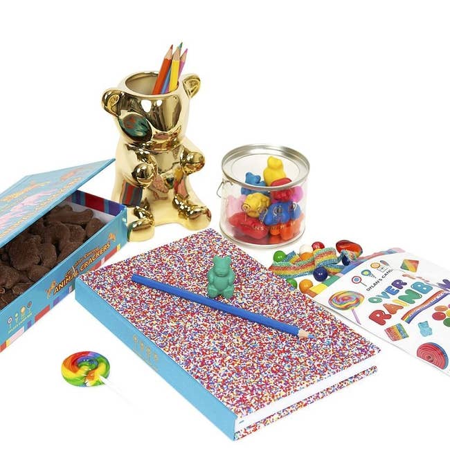 the kit with bag of colorful candy, gold gummy bear pencil cup, sprinkle notebook, gummy bear erasers, and box of animal crackers