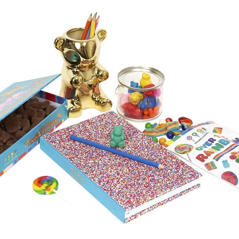 the kit with bag of colorful candy, gold gummy bear pencil cup, sprinkle notebook, gummy bear erasers, and box of animal crackers