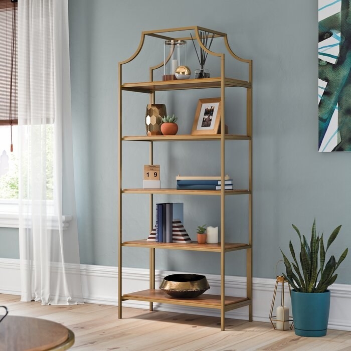 gold open-shelved bookcase in a well-lit room