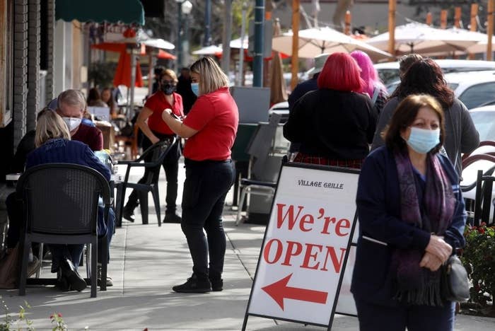 restaurant with a sign pointing inside saying they&#x27;re open