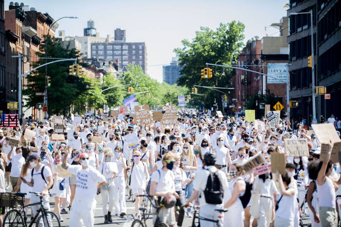 People in the street gather wearing white clothes