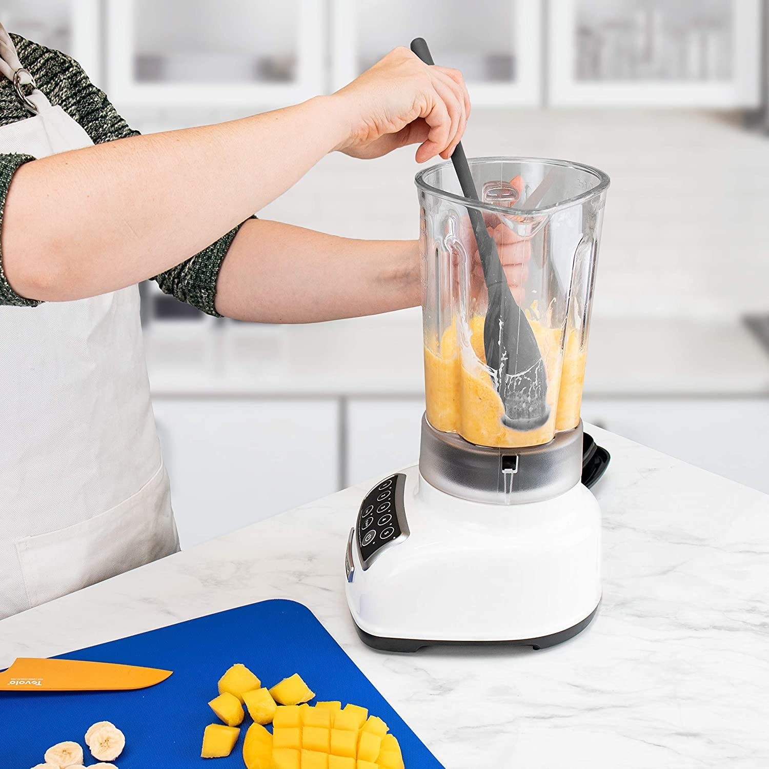 A person using the spatula in their blender