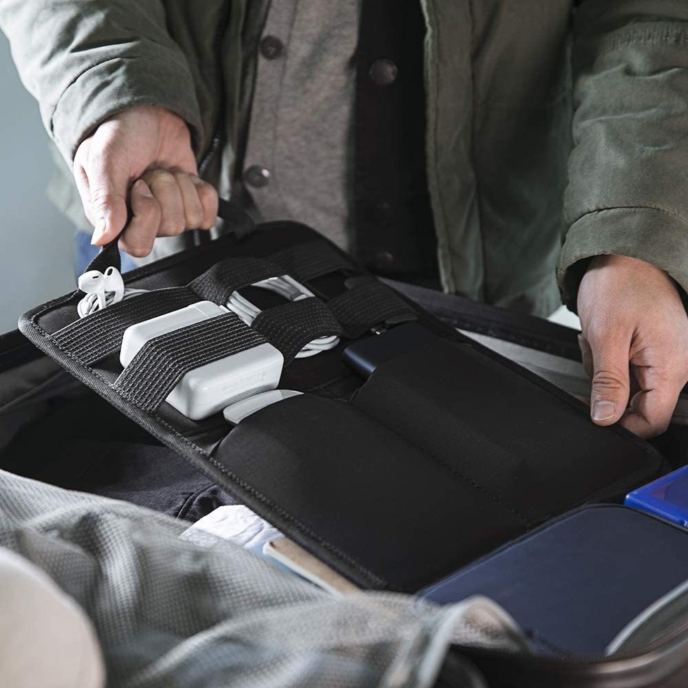 A person putting the sleeve into their suitcase