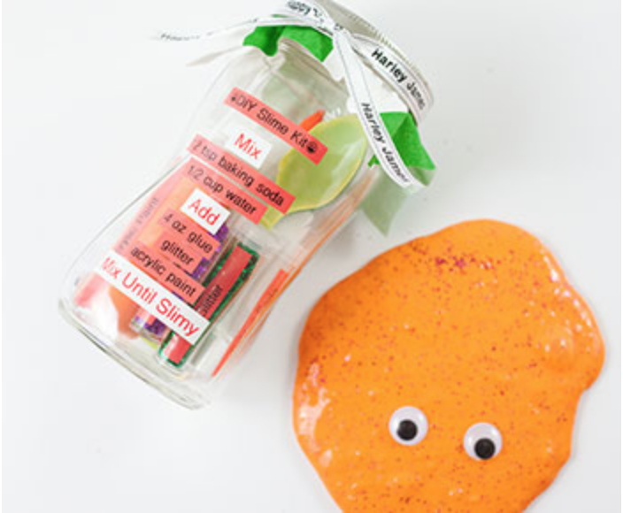 Customized slime kit pictured with orange slime with googly eyes on the side.