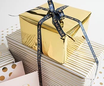 Two presents, stacked on top of each other with customized ribbons.