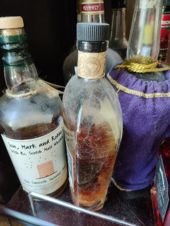 Reviewer image of grime and pet hair on liquor bottles