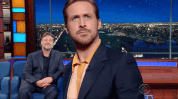 A gif of Ryan Gosling on the Late Show with Stephen Colbert waving goodbye frantically