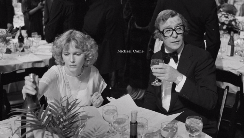 Michael Caine and Mia Farrow at a dinner table