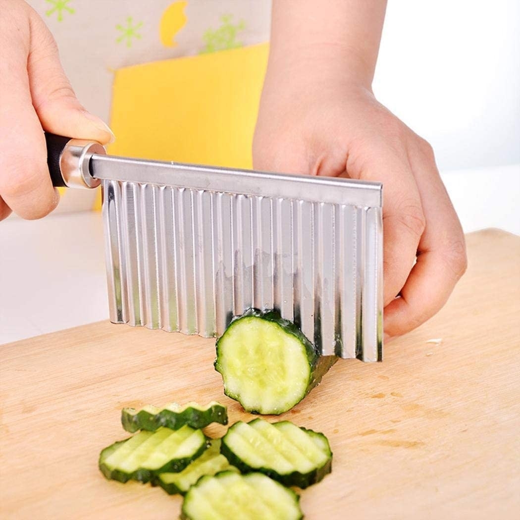A person chopping a zucchini with the crinkle cutter