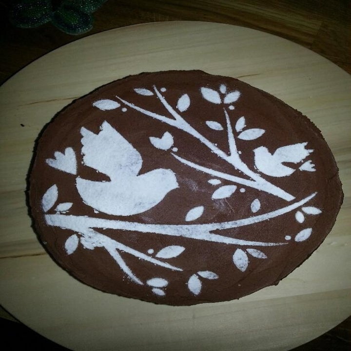 a reviewer's chocolate cake with a delicate powdered sugar design on it