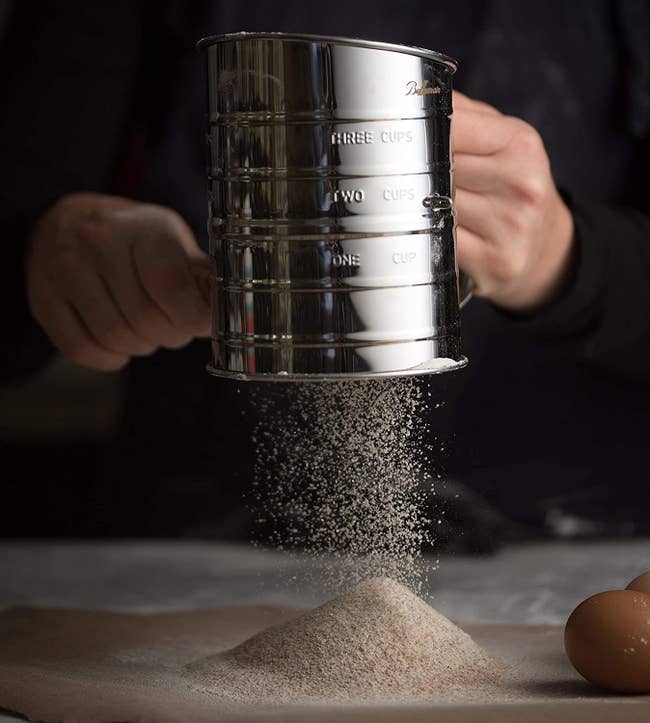 a model sifting flour through the stainless steel sifter