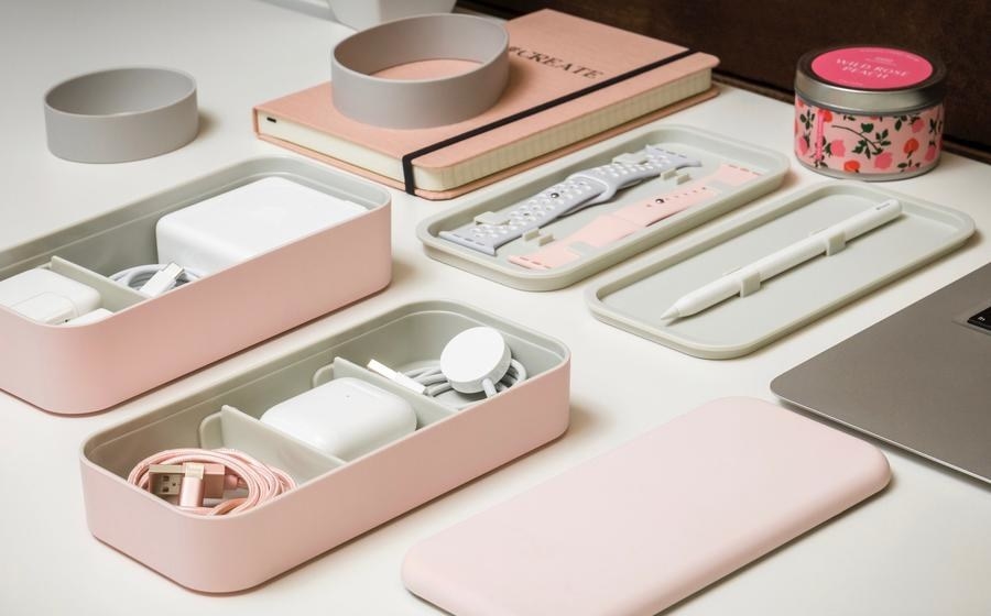 rectangle-shaped box with different layers in pink and different Apple products in each layer