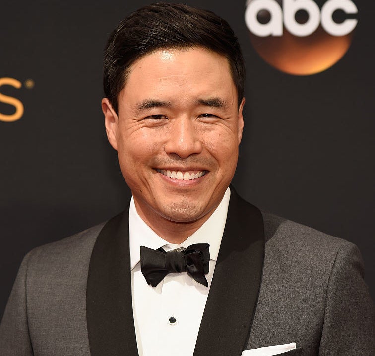 Randall Park wearing a suit and black bow tie at the Emmys red carpet