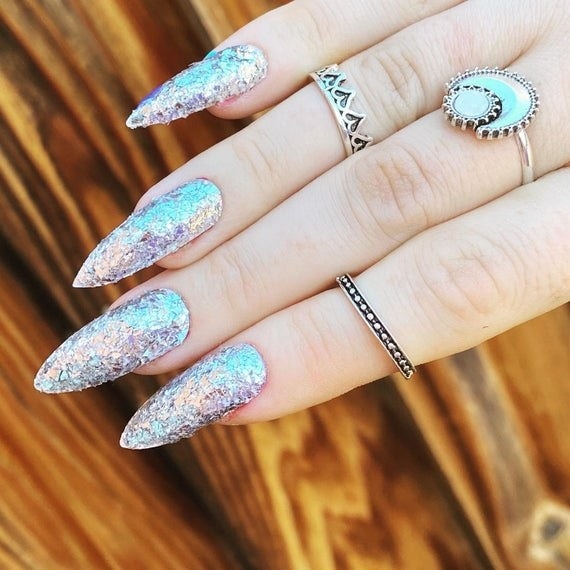 fingers with long silver glittery press-on nails inspired by &#x27;LOTR&#x27; Aragon sword