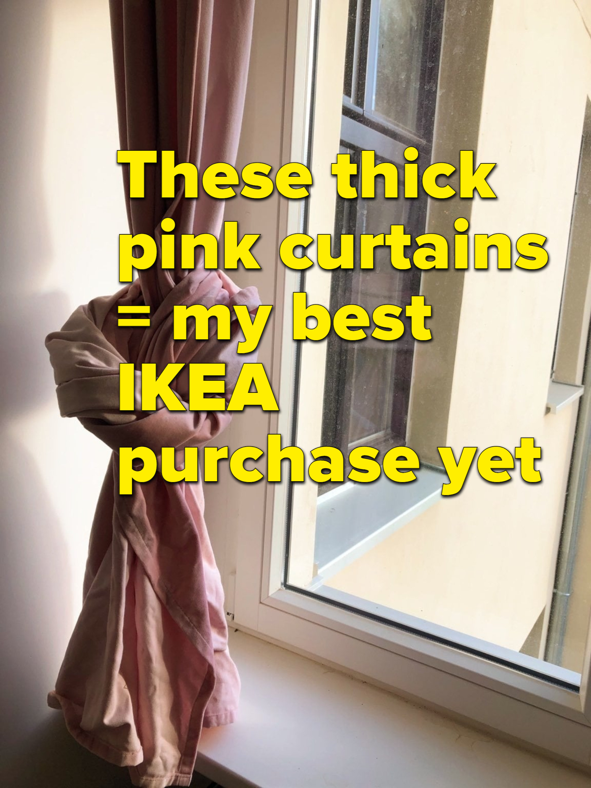 厚厚的粉色窗帘挂钩的窗口,与文本覆盖阅读,“这些厚窗帘=我最好的宜家购买yet"