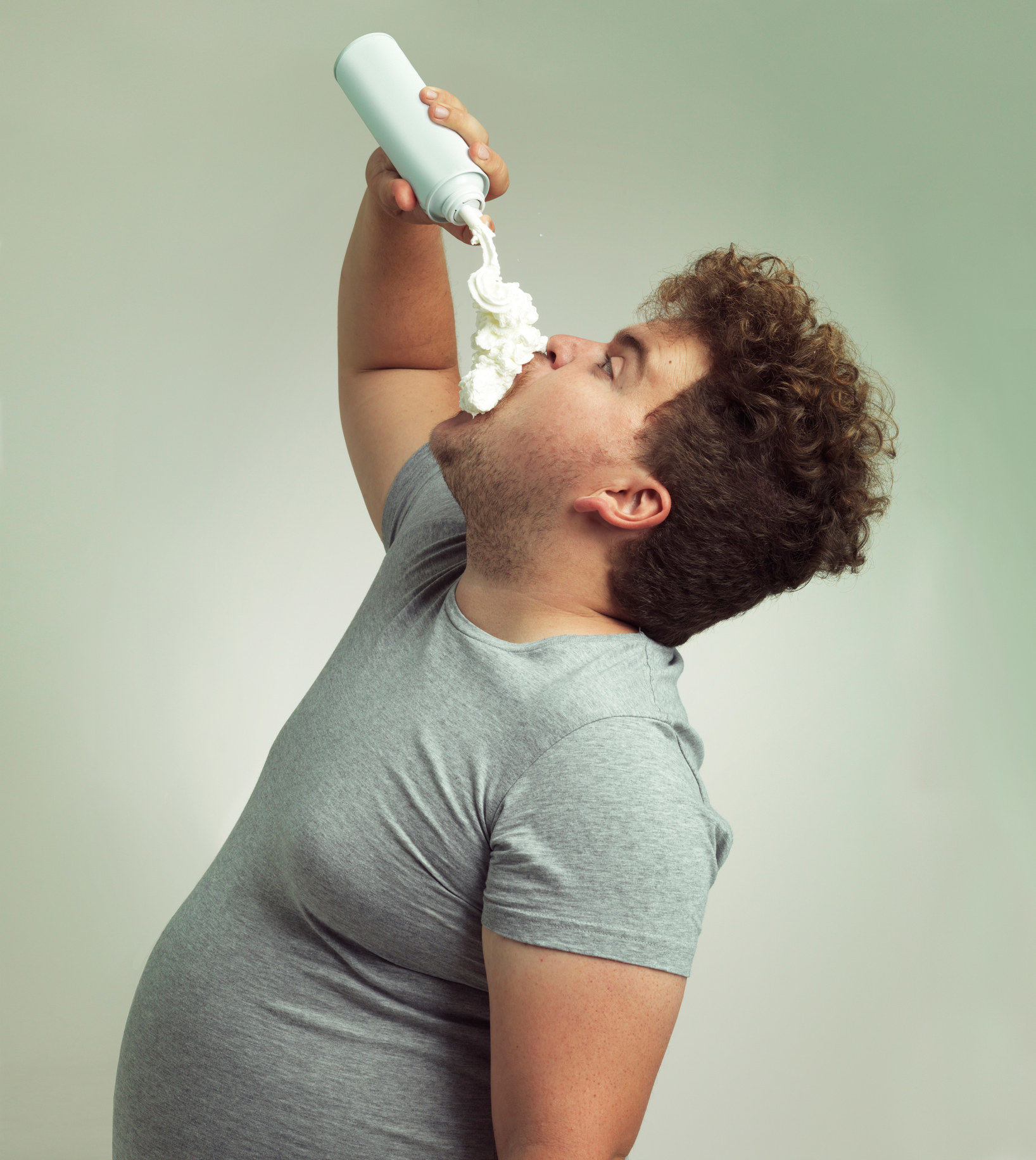 Shot of a man filling his mouth with whipped cream