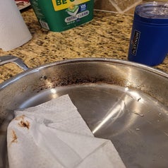 a pan being cleaned with the towel