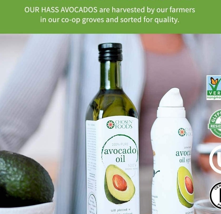 The bottle of avocado oil next to a bowl of avocados