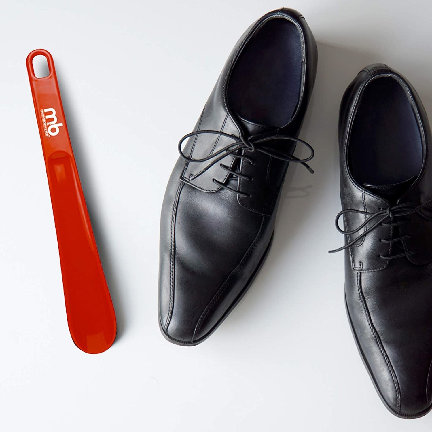 A shoe horn beside a pair of oxfords