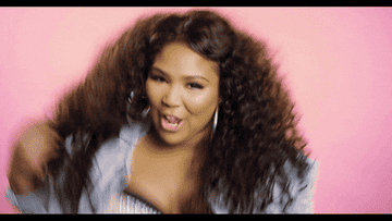 Lizzo dancing and showing off her cool manicure