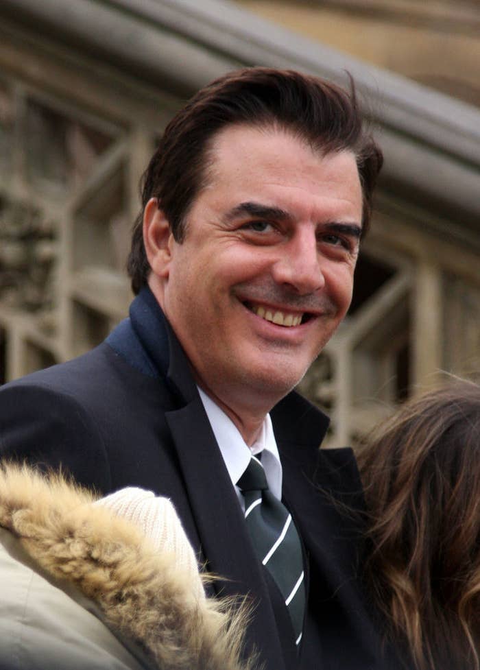 Actor Chris Noth smiling in a suit and tie on location for a Vogue &quot;Sex and the City&quot; photo shoot